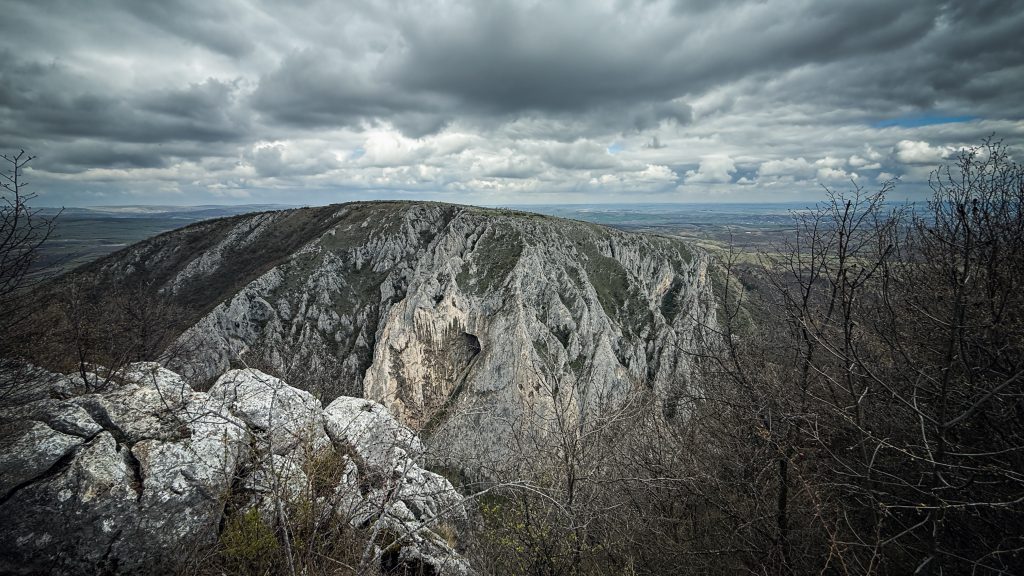 Wide-angle view from the right ridge in Turda Gorge, with rock cliffs and dramatic clouds